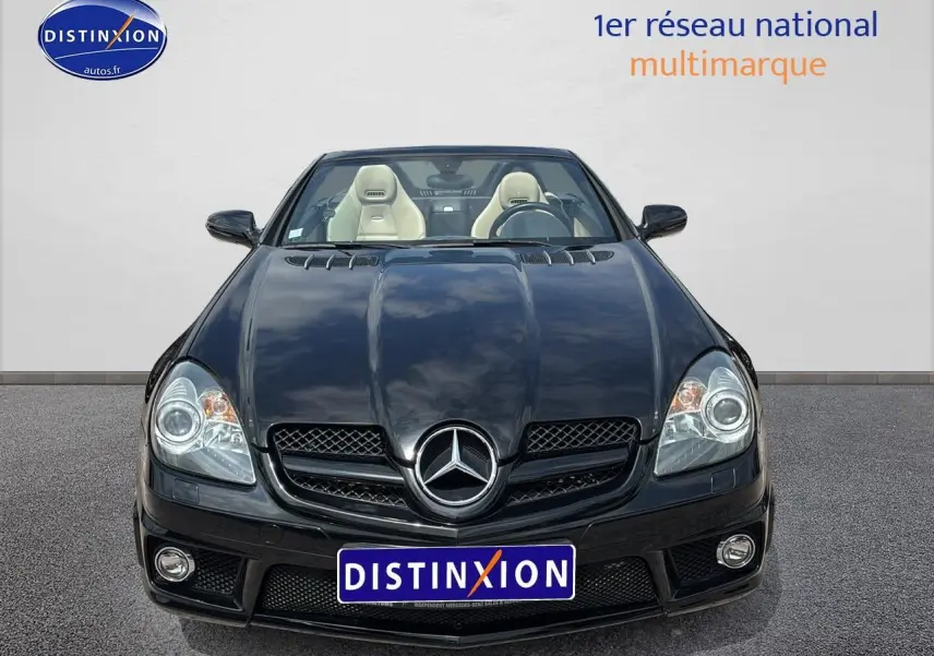 Vue frontale d'une Mercedes SLK 55 AMG noire de 2009, découvrable avec sièges cuir clairs visibles.