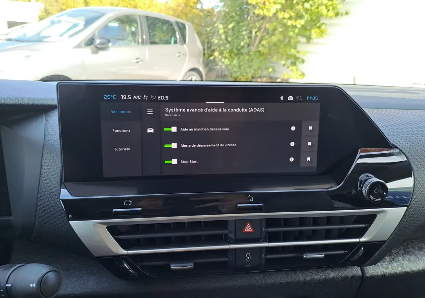 Vue intérieure du tableau de bord du Citroën C4 hybride 2025, écran tactile affichant les aides à la conduite.