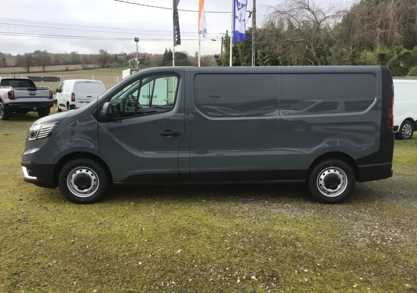 Vue de profil côté gauche du Renault Trafic Fourgon gris urbain 2025, avec porte latérale coulissante et jantes acier.
