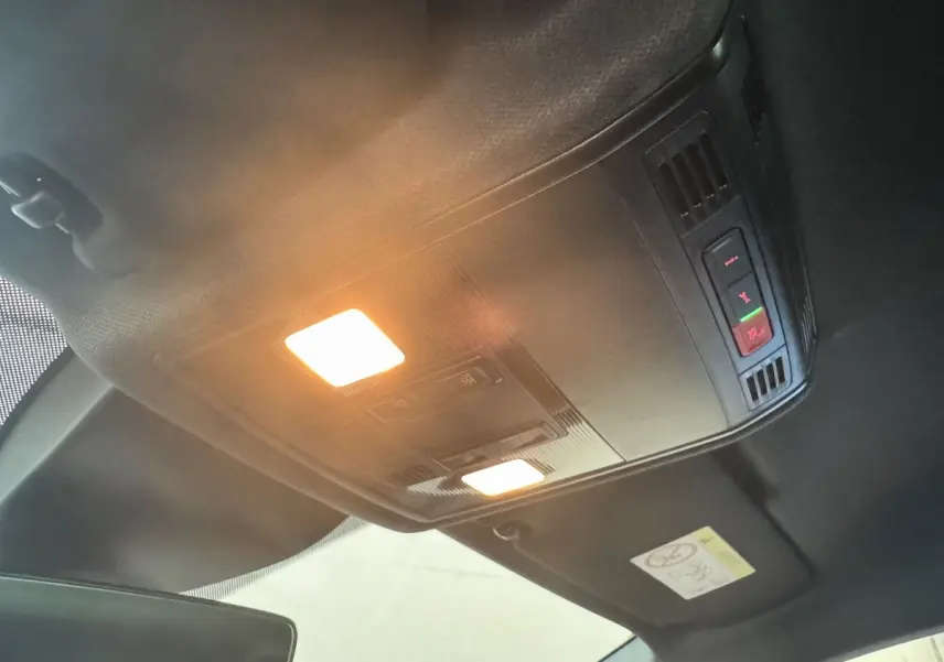 Plafonnier intérieur allumé avec commandes d'urgence et éclairage ambiant dans une SEAT IBIZA 2024 rouge.