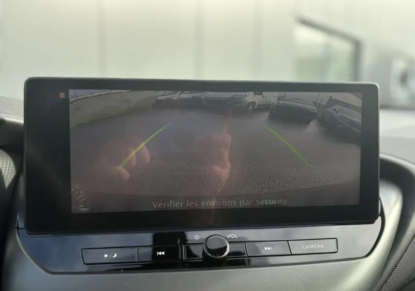 Écran tactile du système de navigation NissanConnect montrant la caméra de recul du Nissan Juke gris foncé, vue intérieure avant.
