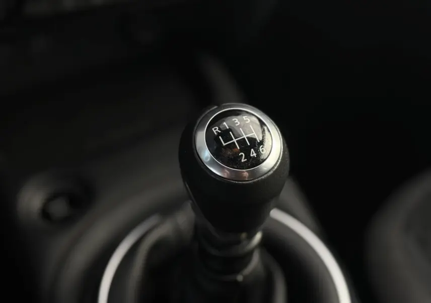 Gros plan sur le levier de vitesses manuel noir du Nissan Juke 2025, version essence Dark Grey.