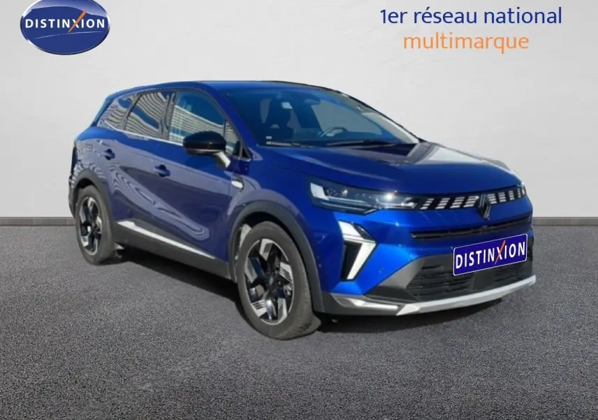 Renault Symbioz 2025 bleu Iron Metal en 3/4 avant droit, SUV hybride avec calandre moderne et jantes stylisées.
