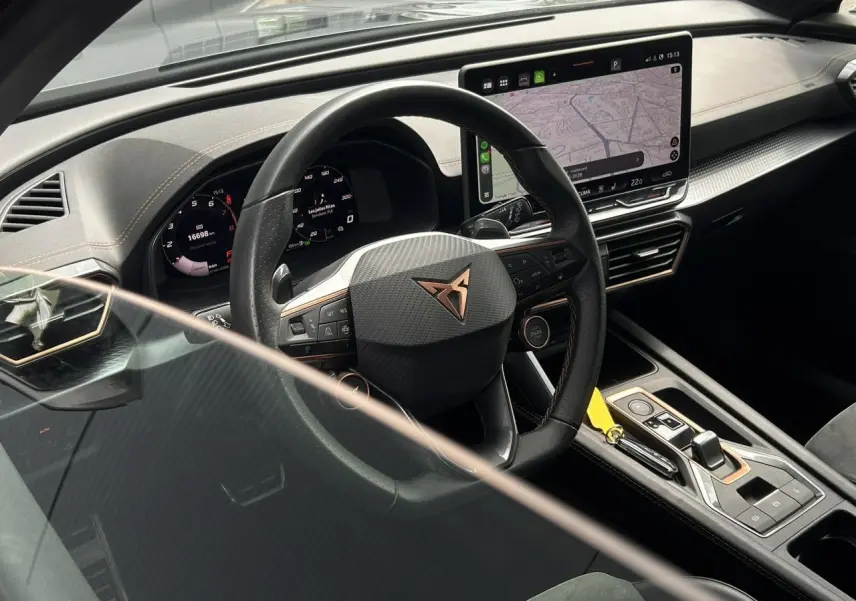 Vue intérieure côté conducteur du CUPRA Formentor 2025, volant cuir noir avec logo cuivre et écran tactile central.