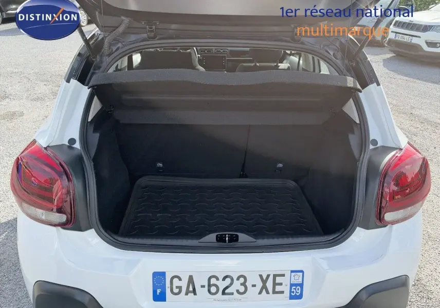Coffre ouvert vu de l'arrière d'une Citroën C3 blanche de 2021 avec feux arrière rouges et plaque française.