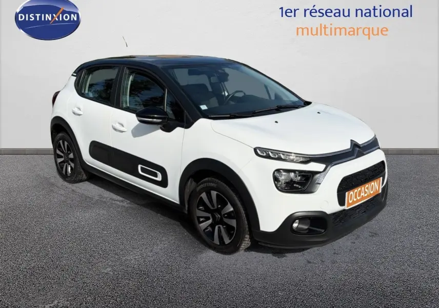 Citroën C3 blanche vue 3/4 avant droit, avec toit noir et protections latérales noires distinctives.