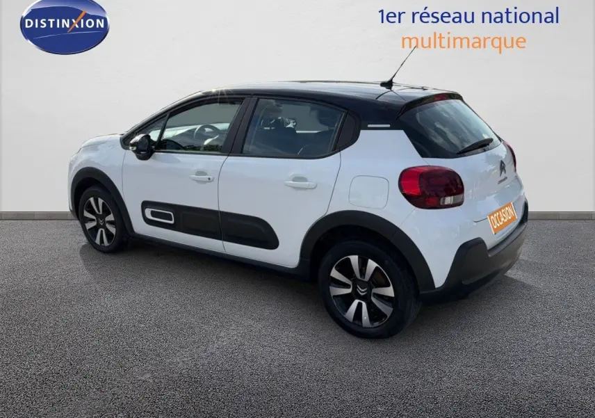 Citroën C3 blanche vue 3/4 arrière droit, toit noir et protections latérales noires distinctives.