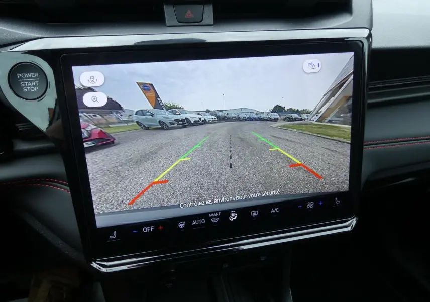 Écran tactile intérieur montrant la caméra de recul du Ford Puma gris métallisé, vue arrière du parking avec lignes de guidage colorées.