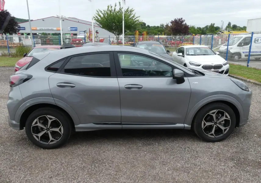 Ford Puma 2025 gris métallisé vu de profil côté gauche, avec jantes alliage 17 pouces et vitres arrière surteintées.