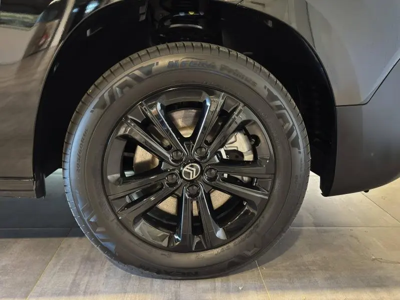 Gros plan sur la roue avant droite noire brillante du Citroën Berlingo Fourgon 2025 Noir Perla Nera nacré.