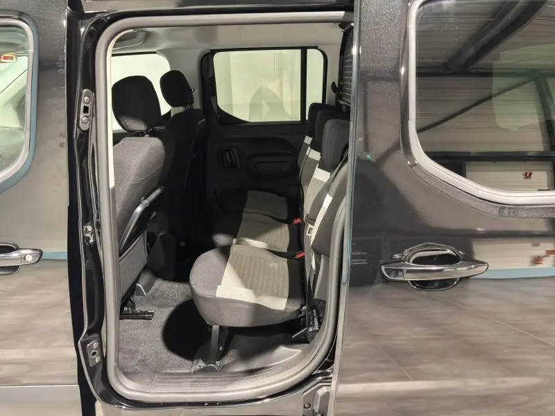 Vue côté gauche sur l'intérieur arrière noir du Citroën Berlingo Fourgon 2025 avec portes coulissantes ouvertes.