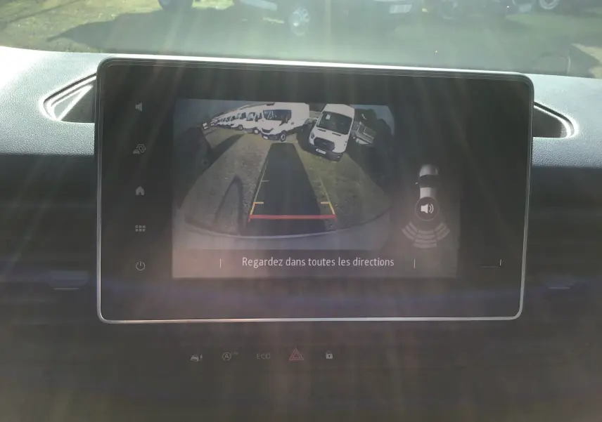 Écran tactile intérieur montrant la caméra de recul du Renault Trafic Fourgon blanc, vue arrière avec lignes de guidage colorées.