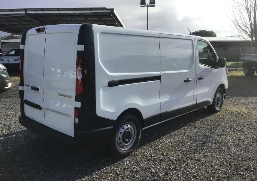 Renault Trafic Fourgon blanc en vue 3/4 arrière droit, avec portes arrière fermées et jantes acier noires.