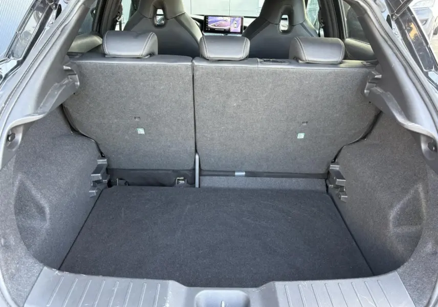 Coffre ouvert du Nissan Juke 2024 Black Pearl, vue arrière montrant l’espace de chargement et les sièges arrière rabattus.