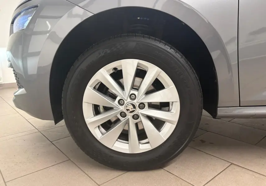 Gros plan sur la roue avant gauche d’un Skoda Kamiq 2023 gris graphite avec jante alliage à dix branches.