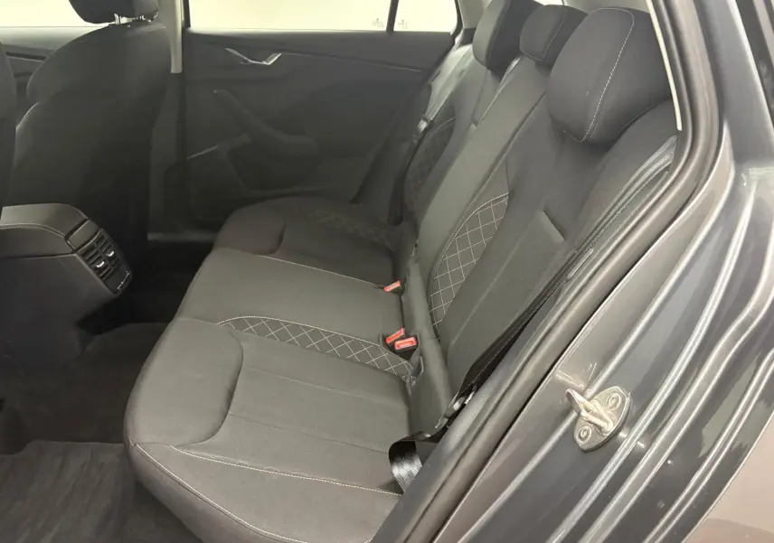 Vue intérieure côté droit des sièges arrière en tissu gris foncé avec surpiqûres, portière ouverte du Skoda Kamiq Gris Graphite 2023.