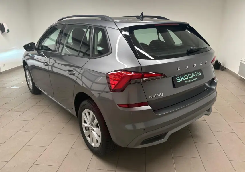 Vue 3/4 arrière droite d'un Skoda Kamiq 2023 gris graphite métallisé, avec feux arrière LED et toit noir contrasté.