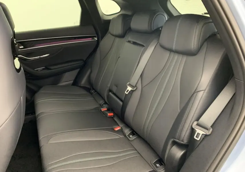 Vue intérieure arrière droite du BYD SEAL U 2025 en Tian Qing, sièges noirs avec surpiqûres et ceintures grises.