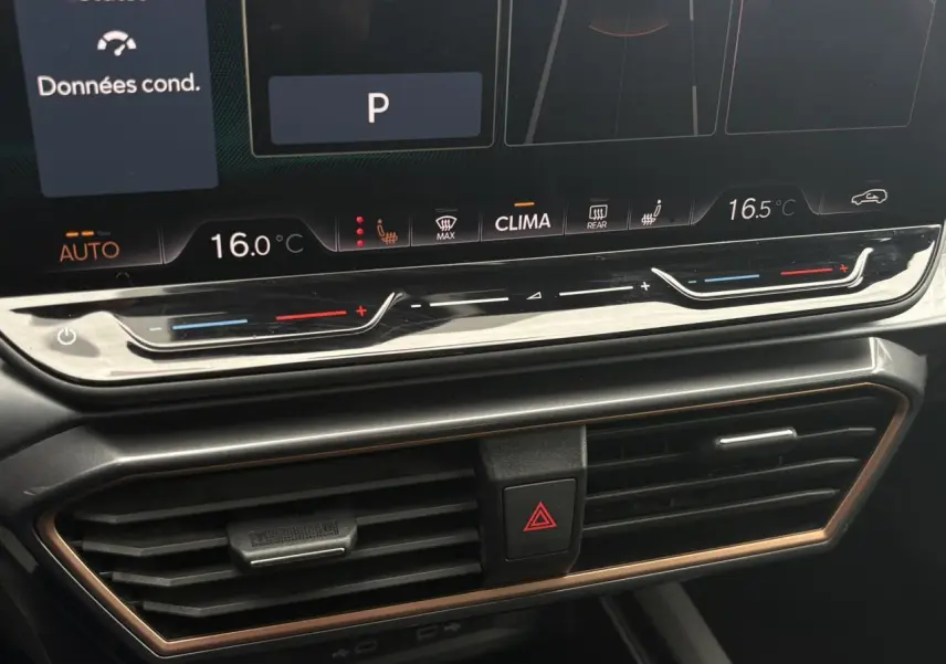 Gros plan sur la console centrale du CUPRA Formentor 2025, affichage digital de la climatisation et aérateurs noirs avec contour cuivre.