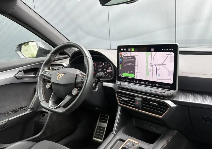 Vue intérieure côté conducteur du CUPRA Formentor noir Minuit, avec volant multifonction et écran tactile de navigation visible.