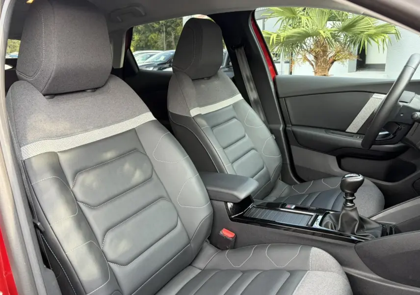 Vue intérieure côté avant droit de la Citroën C4 1.2 PureTech 130 Max avec sièges Advanced Comfort gris et volant cuir.