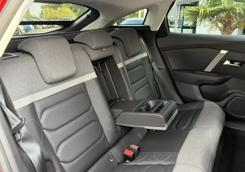 Vue intérieure côté droit des sièges arrière gris et noir avec accoudoir central déplié de la Citroën C4 2024.