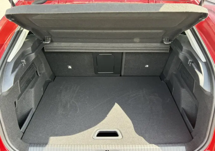 Coffre ouvert vu de l'arrière d'une Citroën C4 Rouge Elixir, montrant un espace de chargement propre et modulable.