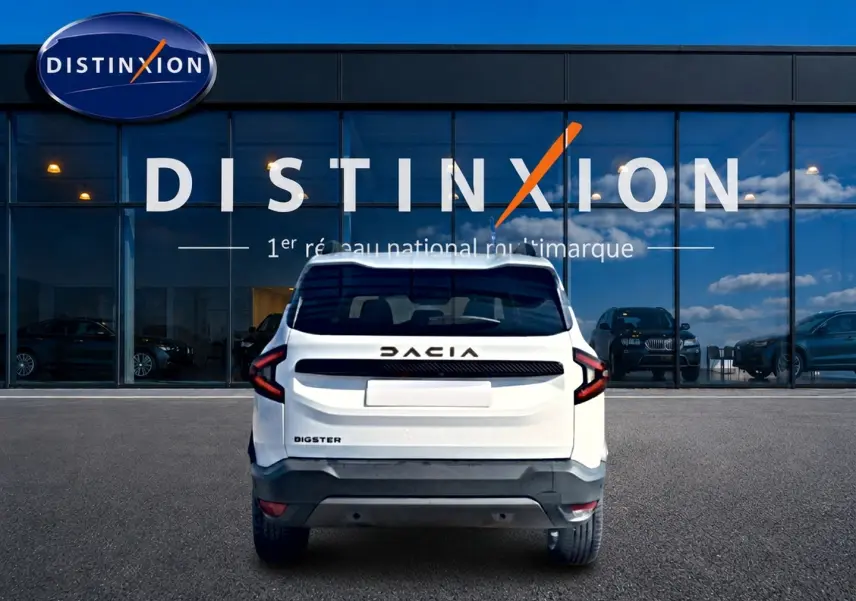 Vue arrière du Dacia Bigster blanc 2026 avec feux arrière en forme de C et logo DACIA noir sur fond blanc.