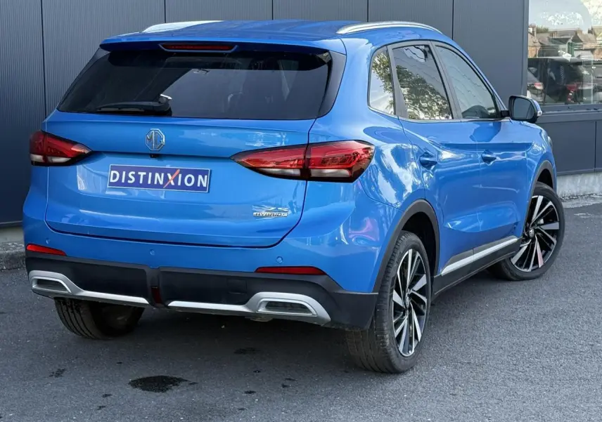 Vue 3/4 arrière droite du MG ZS 1.5 Hybrid+ 197 Luxury bleu Como avec jantes alliage 18 pouces et vitres surteintées.