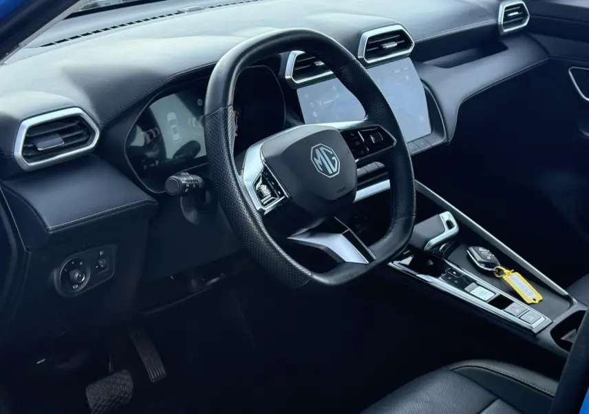 Vue intérieure côté conducteur du MG ZS 1.5 Hybrid+ 197 Luxury avec volant cuir noir et écran tactile central.
