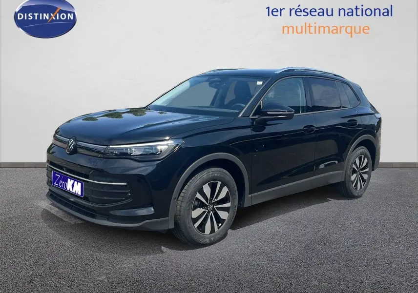 Volkswagen Tiguan noir Grenadilla métal en 3/4 avant droit, avec jantes bicolores et calandre épurée.