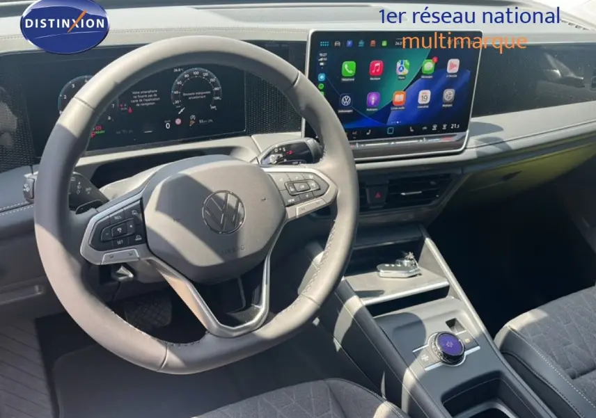 Vue intérieure du Volkswagen Tiguan 2026 montrant le volant multifonction et l'écran tactile central lumineux.