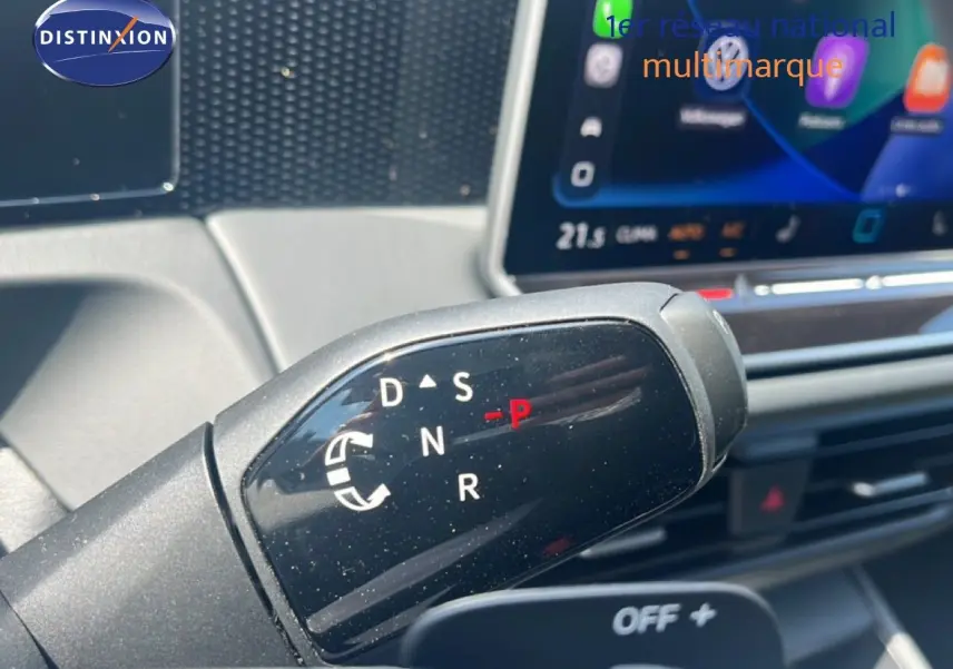 Gros plan sur le levier de vitesses automatique du Volkswagen Tiguan noir Grenadilla, avec écran tactile en arrière-plan.