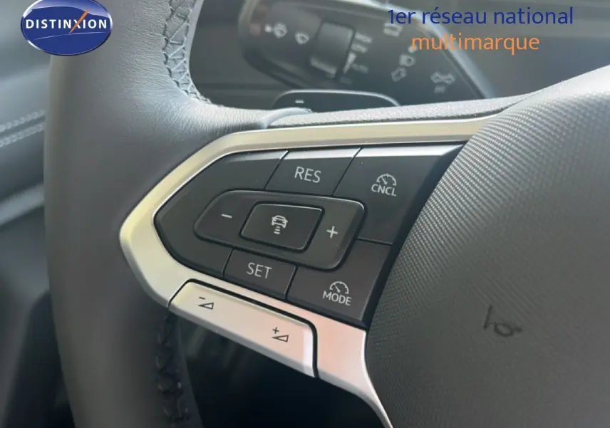 Gros plan sur le volant noir du Volkswagen Tiguan 2026, mettant en valeur les commandes de régulateur de vitesse.