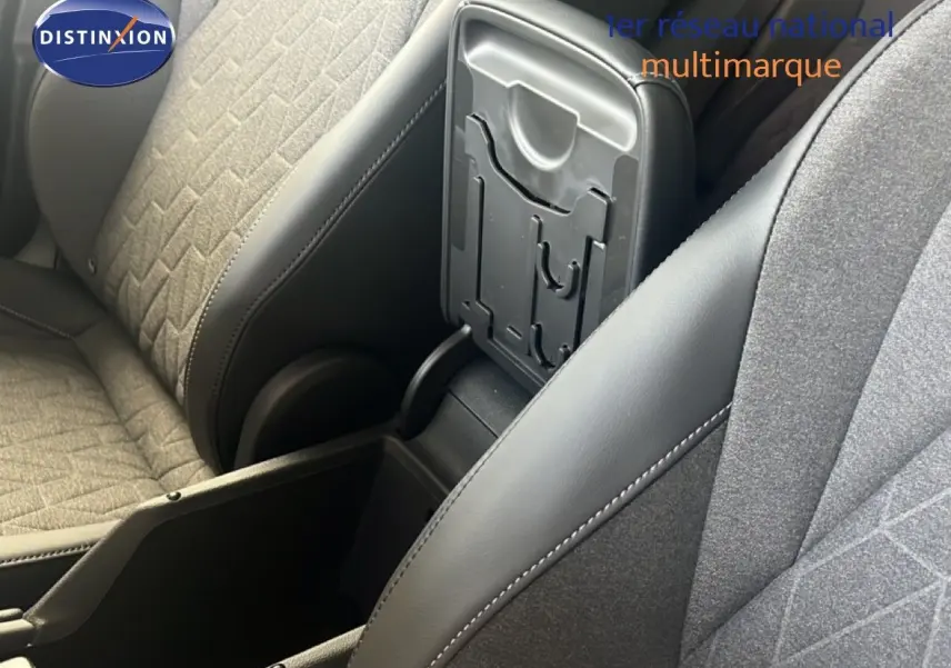 Vue rapprochée de l'accoudoir central ouvert entre les sièges avant en tissu gris et cuir noir du Volkswagen Tiguan 2026.