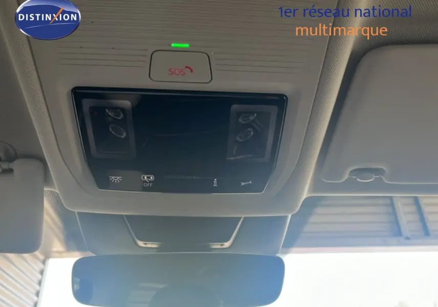 Vue intérieure du plafond avant du Volkswagen Tiguan noir Grenadilla, montrant les commandes d'éclairage et le bouton SOS au-dessus du rétroviseur.