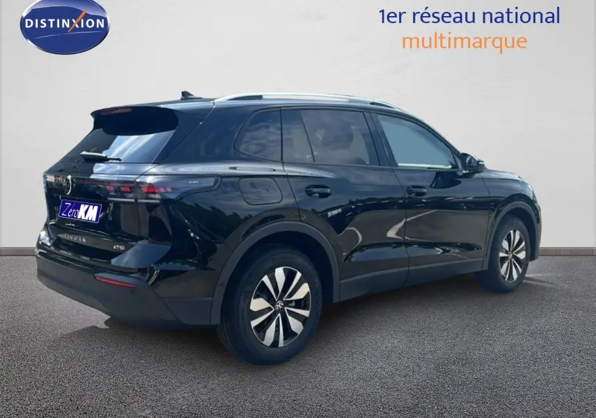 Vue 3/4 arrière droite du Volkswagen Tiguan noir Grenadilla métallisé avec jantes bicolores et toit ouvrant.