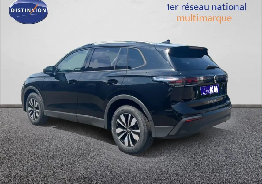Volkswagen Tiguan noir grenadilla métal vu en 3/4 arrière droit, soulignant ses lignes modernes et ses jantes bi-ton.