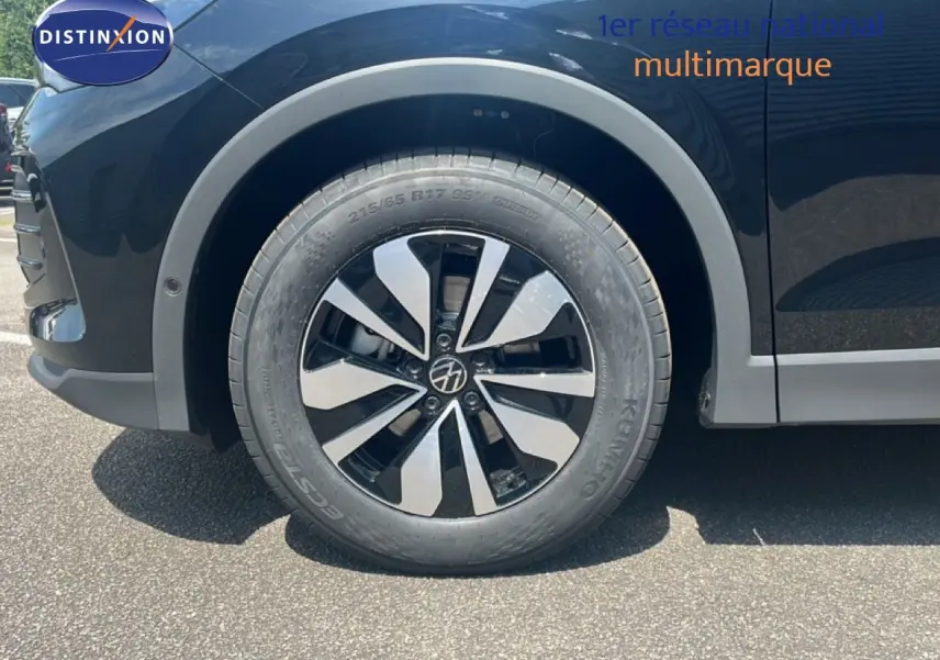 Gros plan sur la roue avant gauche du Volkswagen Tiguan noir Grenadilla, mettant en valeur la jante bi-ton distinctive.