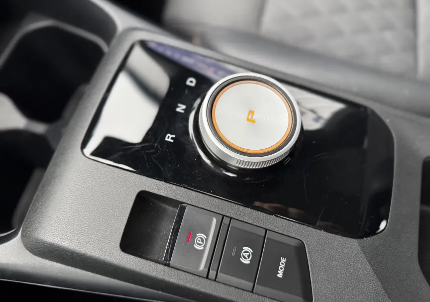 Gros plan sur la molette de sélection de vitesse et les boutons de commande sur la console centrale noire du MG3 1.5 HYBRID+ 195 LUXURY.