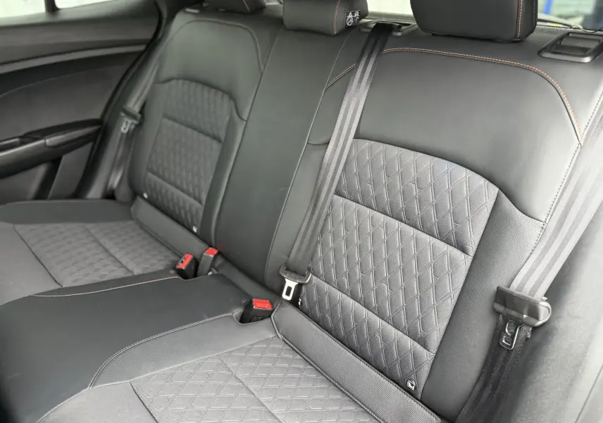 Vue intérieure des sièges arrière en cuir noir avec surpiqûres orange du MG3 1.5 HYBRID+ 195 LUXURY 2025.
