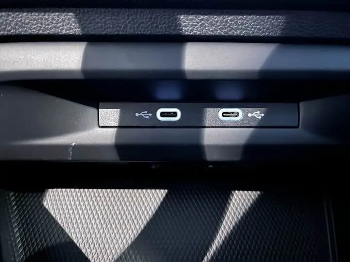 Gros plan sur deux ports USB-C intégrés dans la console intérieure d'une Volkswagen Golf 8 reflet d'argent.