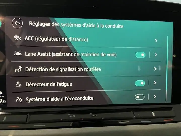 Écran tactile intérieur de la Volkswagen Golf 8 affichant les réglages des aides à la conduite.