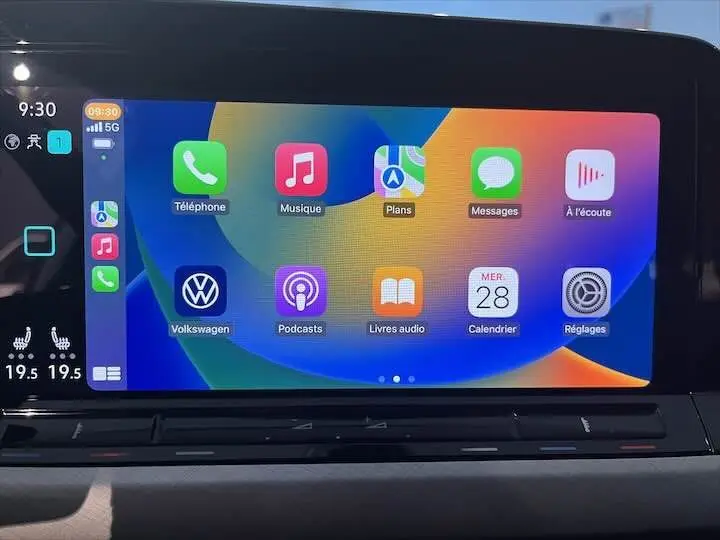 Écran tactile central de la Volkswagen Golf 8 en mode Apple CarPlay avec interface colorée et commandes de climatisation visibles.