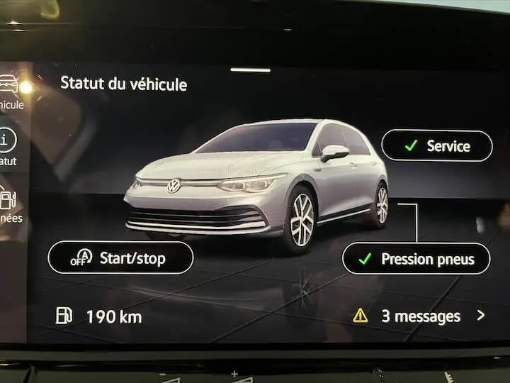 Affichage numérique montrant une Volkswagen Golf 8 argent en 3/4 avant avec icônes de service et pression pneus validées.