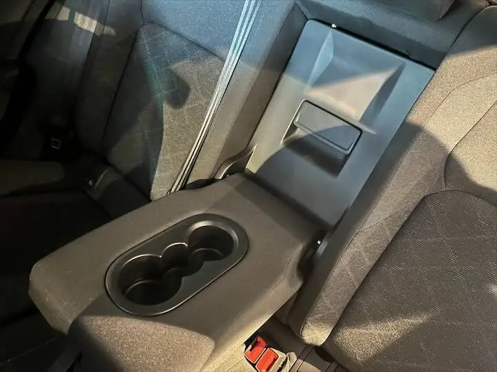 Gros plan sur l'accoudoir arrière avec porte-gobelets et tissu noir de la Volkswagen Golf 8 1.0 E TSI 2021.