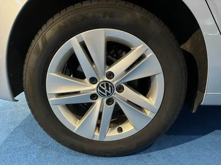 Gros plan sur la roue avant gauche d'une Volkswagen Golf 8 argent métal, jante en alliage à cinq branches.