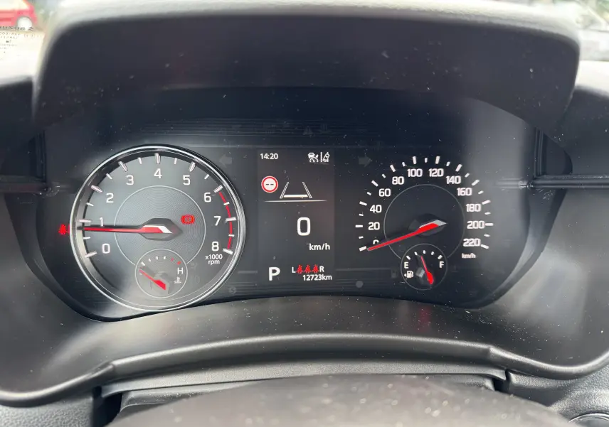 Vue rapprochée du tableau de bord numérique de la Suzuki Swift bleu, affichant compte-tours, vitesse et jauge de carburant.