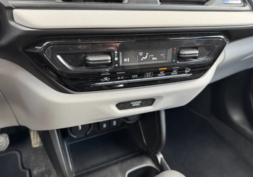 Vue rapprochée de la console centrale de la Suzuki Swift 1.2 Hybrid Privilege Auto 2025, avec commandes climatisation et affichage digital.