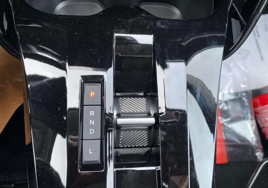 Gros plan sur la console centrale noire brillante avec sélecteur de boîte auto et molette de réglage du Citroën C3 Aircross 2025.